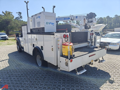 Ford F-550 Super Duty crane truck with mounted aerial boom and toolbox, rear view showing crane and hydraulic controls.
