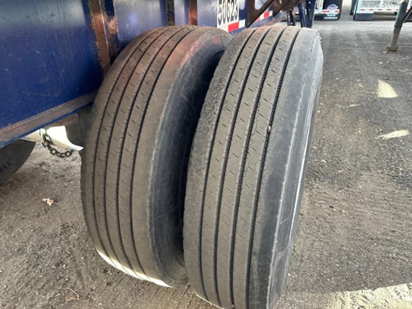 Tandem axle trailer wheels showing four-steel belt tires with no visible tread on Fontaine Infinity trailer.