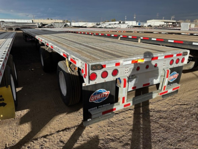 Flatbed trailer showing aluminum deck and rear bumper with red and white reflective tape and Utility/ Fontaine branding on mudflaps.