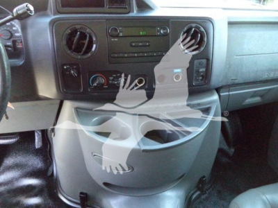 Ford E-Series interior dashboard view showing center console with radio, air vents, climate controls, and cup holder area.