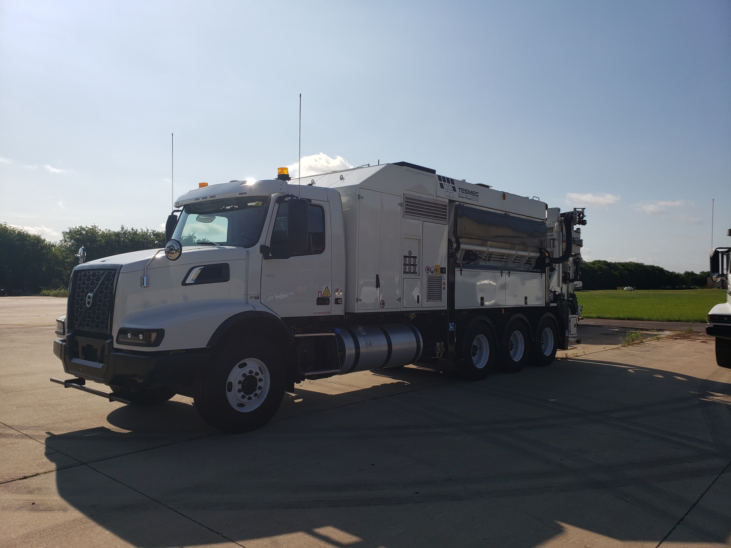 Volvo VHD86B300 truck with trenching equipment in side view showing large generator-style body and hose reels