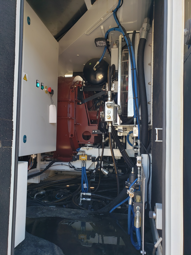 Volvo VHD86B300 trenching truck cabin view showing hydraulic lines, control panel, and engine components.