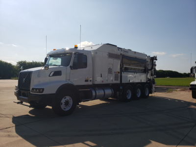 Volvo VHD86B300 truck with trenching equipment in side view showing large generator-style body and hose reels