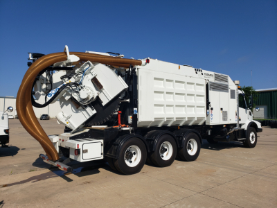 Volvo VHD86B300 trenching truck with large vacuum/auger attachment and white service body, side view showing exhaust and hoses.