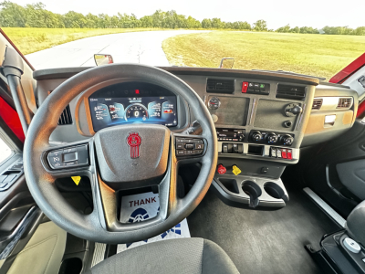 Kenworth T680 dashboard and steering wheel interior showing digital gauges and controls.