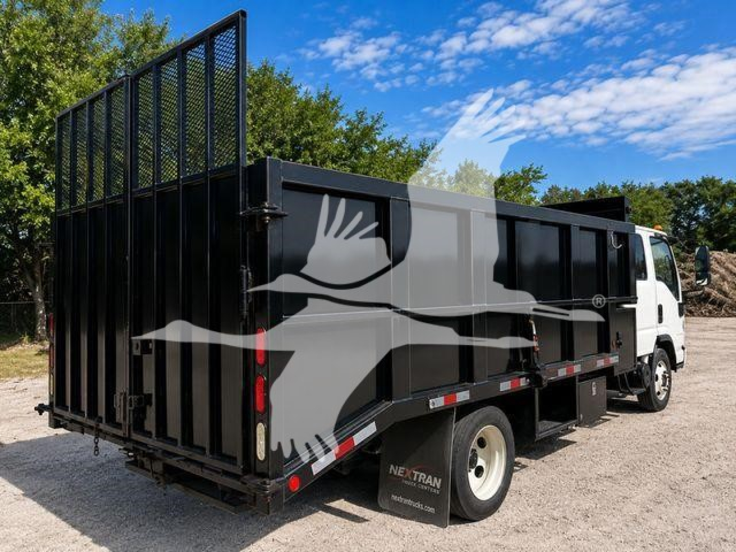Isuzu NPR HD dump truck with black steel dump bed and high side panels, side view showing rear stake bed and white cab.