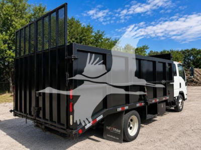 Isuzu NPR HD dump truck with black steel dump bed and high side panels, side view showing rear stake bed and white cab.