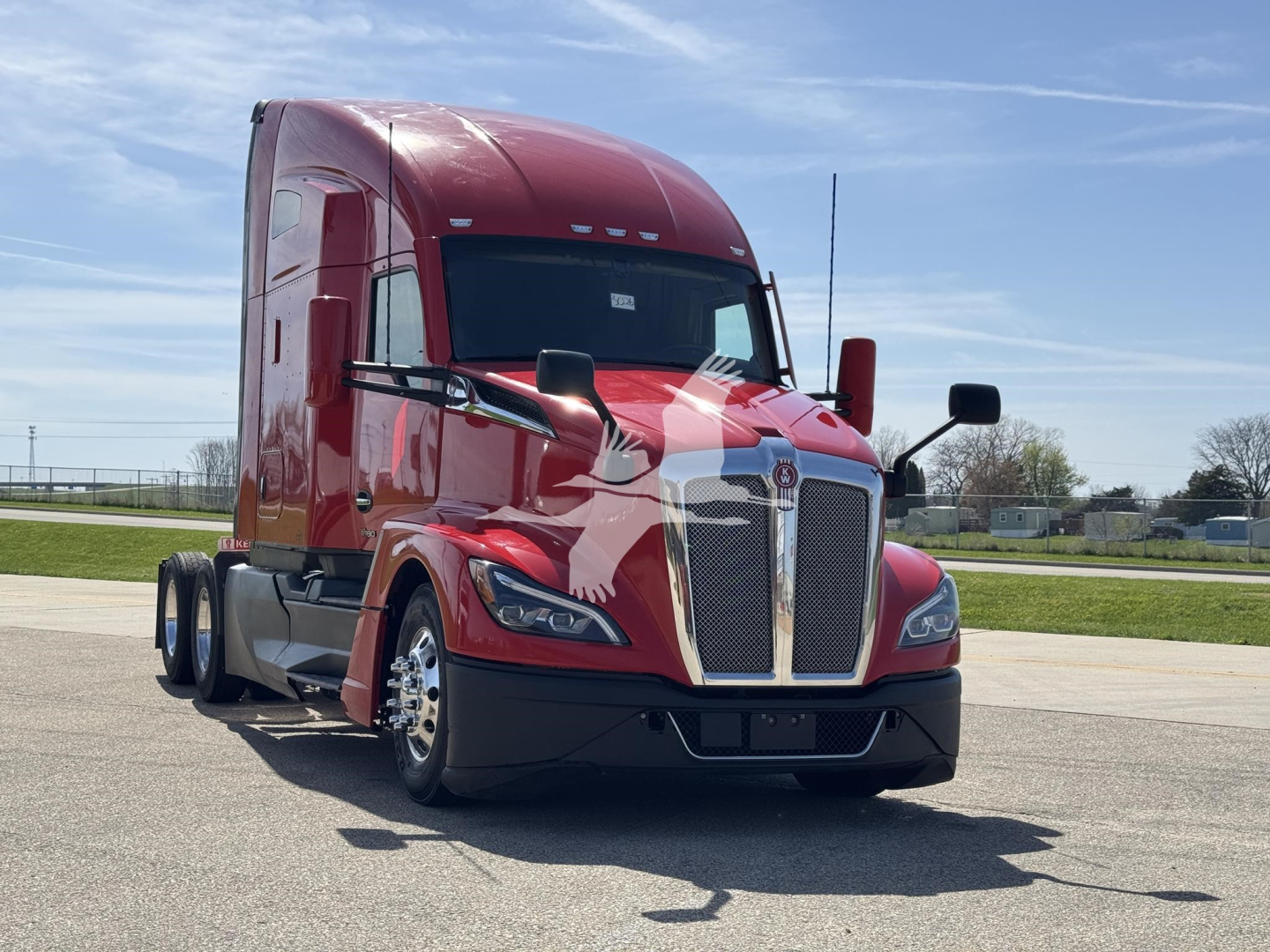 Kenworth T680 conventional sleeper truck in red, front-left view, showing grille, headlights, chrome bumper, and large side mirrors