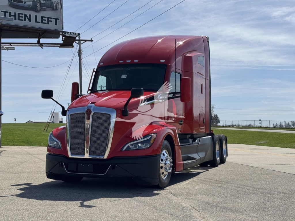 Kenworth T680 tractor-trailer in red, front three-quarter view, with tall sleeper cab and dual rear axles, highway in background.