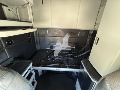 Kenworth T680 sleeper cab interior cargo area with metal walls and storage compartments visible.