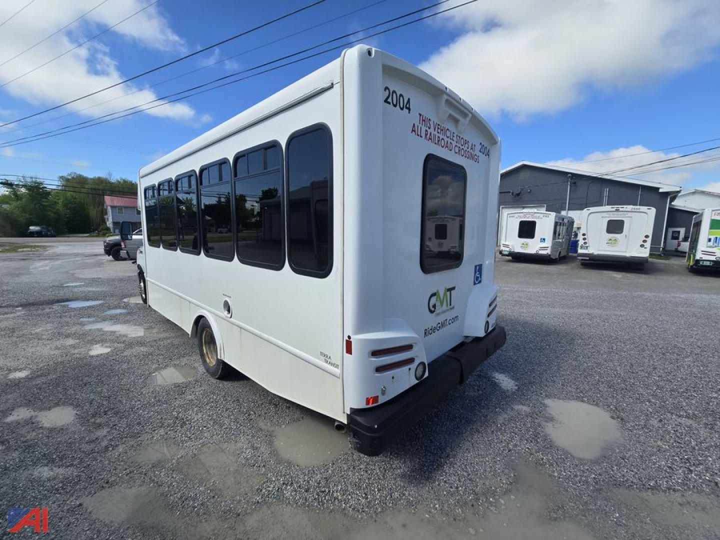 Ford E-450 shuttle bus rear three-quarter view showing wheelchair accessible rear door and windowed passenger cabin.
