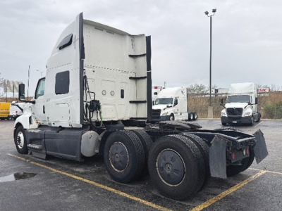 Tractor unit shown from side/rear angle with sleeper cab and dual rear axles on a cargo tractor.