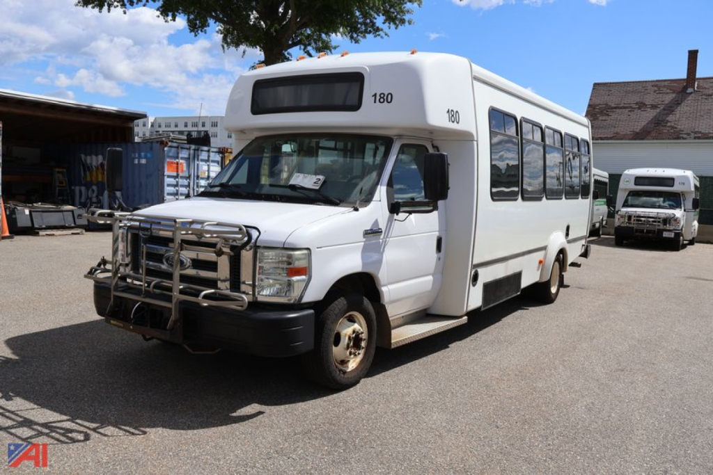 2019 Ford E450 wheelchair bus front-right view showing bus with chrome grille guard and side windows.