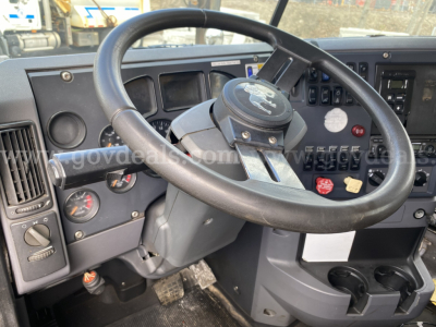 Mack GU713 truck interior showing steering wheel and dash with gauges and switches.