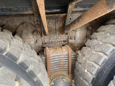 Mack GU713 truck undercarriage showing differential housing and leaf spring suspension between dual rear tires.
