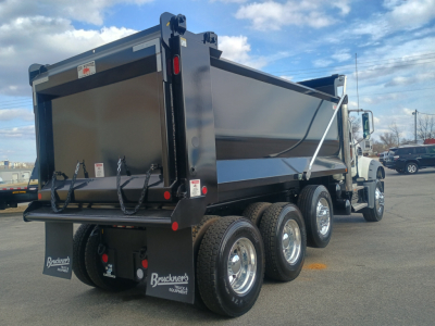 Truck dump body rear view showing Brackner’s mud flaps and triple rear tires on a new Mack GR84F dump truck.