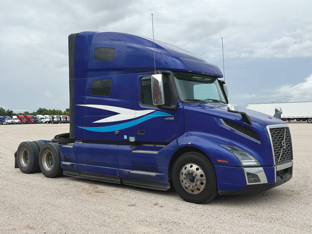 Volvo VNL 760 truck in blue cab, side view showing sleeper cab and chrome exhaust, no identifying plates visible.