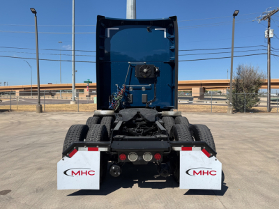 Kenworth T680 tractor rear view showing fifth wheel, rear lights, mud flaps with MHC logo, and dual rear axles.