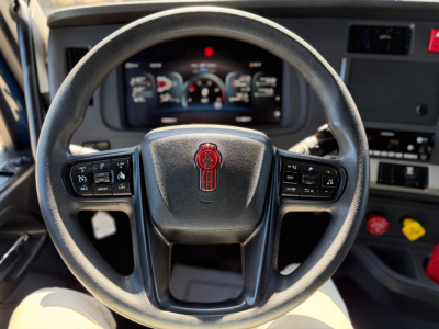 Steering wheel and dashboard of a Kenworth T680 cab showing instrument cluster and controls.