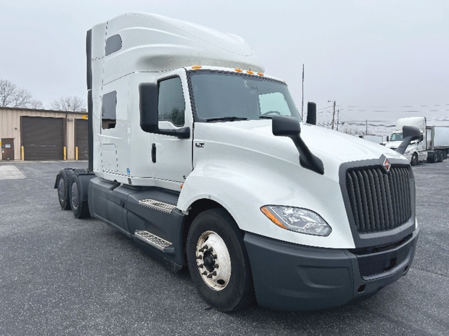 Truck front and side view with cab over engine, International LT625 sleeper tractor. Visible text not legible except general truck shape.