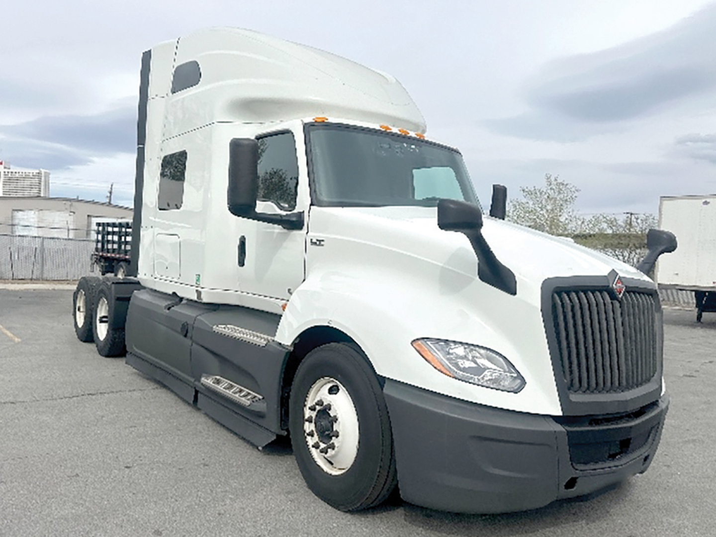 Truck image: 2023 International LT625 conventional sleeper tractor with white cab, black grille, and sleeper cab. Visible text includes no legible stickers; generic truck features and stock details.