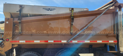 Dump truck bed with side rails and hydraulic hopper release; visible text on the tarp cover reads 'Swenson spreader' and there are red and white reflective stripes along the side.