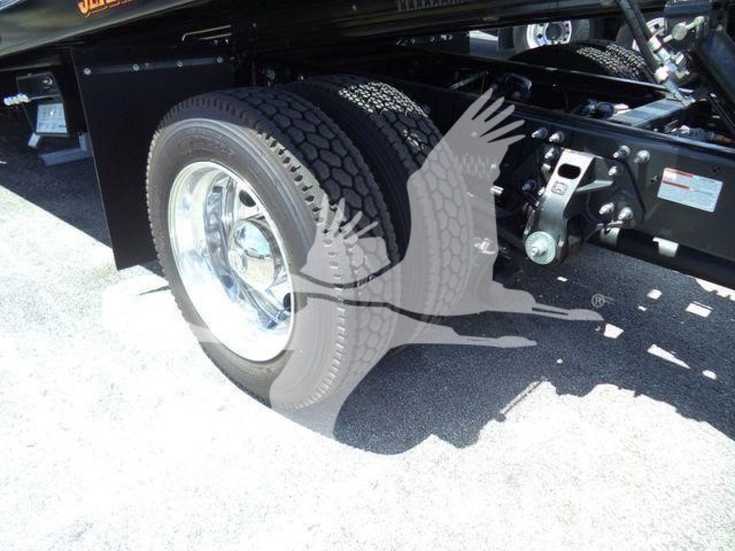 Chassis area of a 2026 Hino L6 rollback truck showing rear wheel and suspension components.