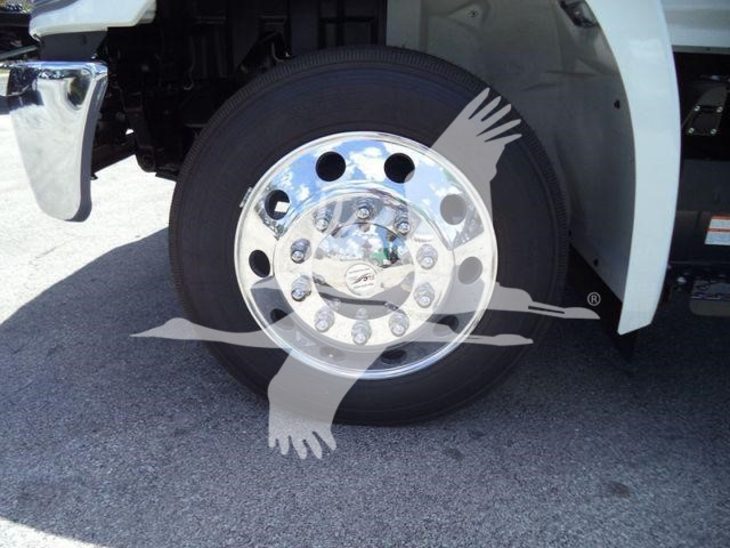 Front wheel and chrome hubcap of a new 2026 Hino L6 rollback truck showing wheel and tire.
