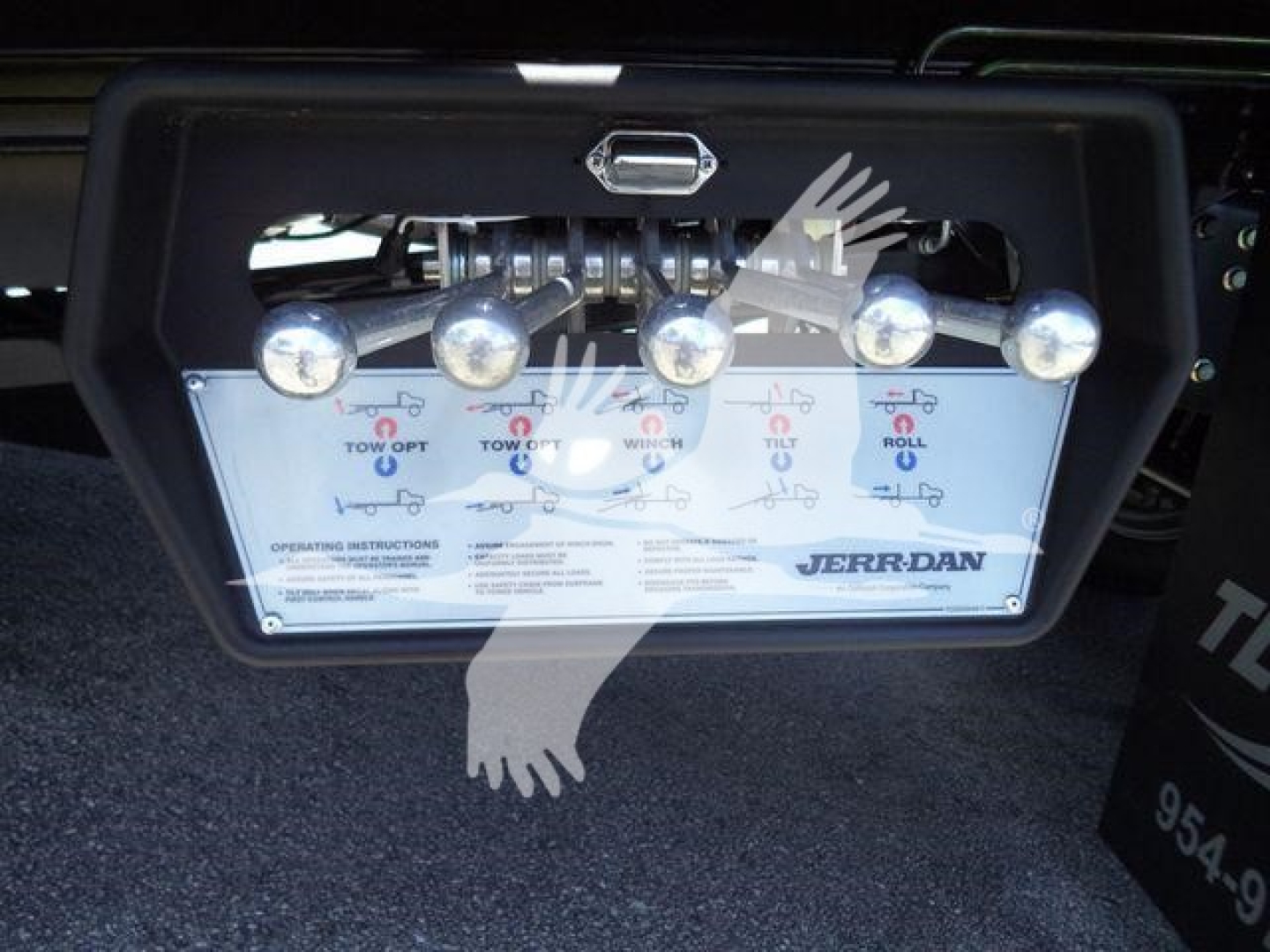 Rear control panel of a JERR-DAN rollback body showing five indicator lights and levers for tow operations, with brand name on panel.