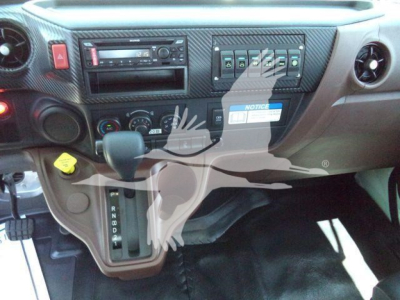 Dashboard and gear selector area of a new 2026 Hino L6 rollback truck showing center console controls and gear lever.
