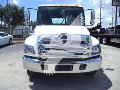 Front view of a white 2026 Hino L6 truck showing chrome grille and bumper with Hino emblem