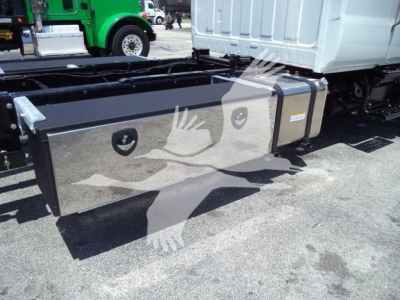 Hino L6 rollback truck chassis with long rectangular aluminum toolbox on side, mounted under cab, with straps and mounting brackets visible.