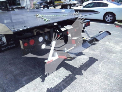 Hino L6 rollback truck rear showing hydraulic ramps and tow components with metal platform and safety chains