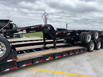 Trailer show with multiple axles and a gooseneck hitch; visible labeling reads A80JD and Alpha branding on the trailer.