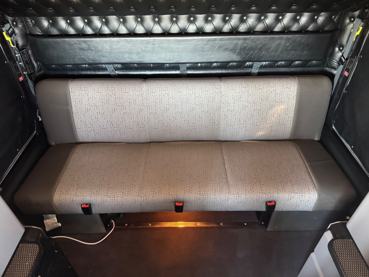 Kenworth W900L sleeper truck interior bench seat with dotted fabric and black side panels, cargo area lighting, VIN and stock details not visible in image.