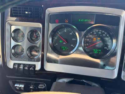 Kenworth W900L dashboard with multiple gauges and digital clock showing 9:45 AM.