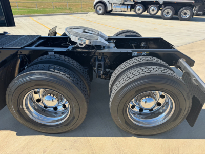 Kenworth W900L truck rear dual-axle configuration showing dual rear tires and fifth-wheel mounting area with fuel/tank area and chassis rails.