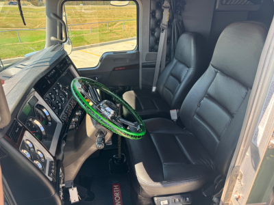 Kenworth W900L truck interior showing steering wheel and driver seat with dashboard and control panel.