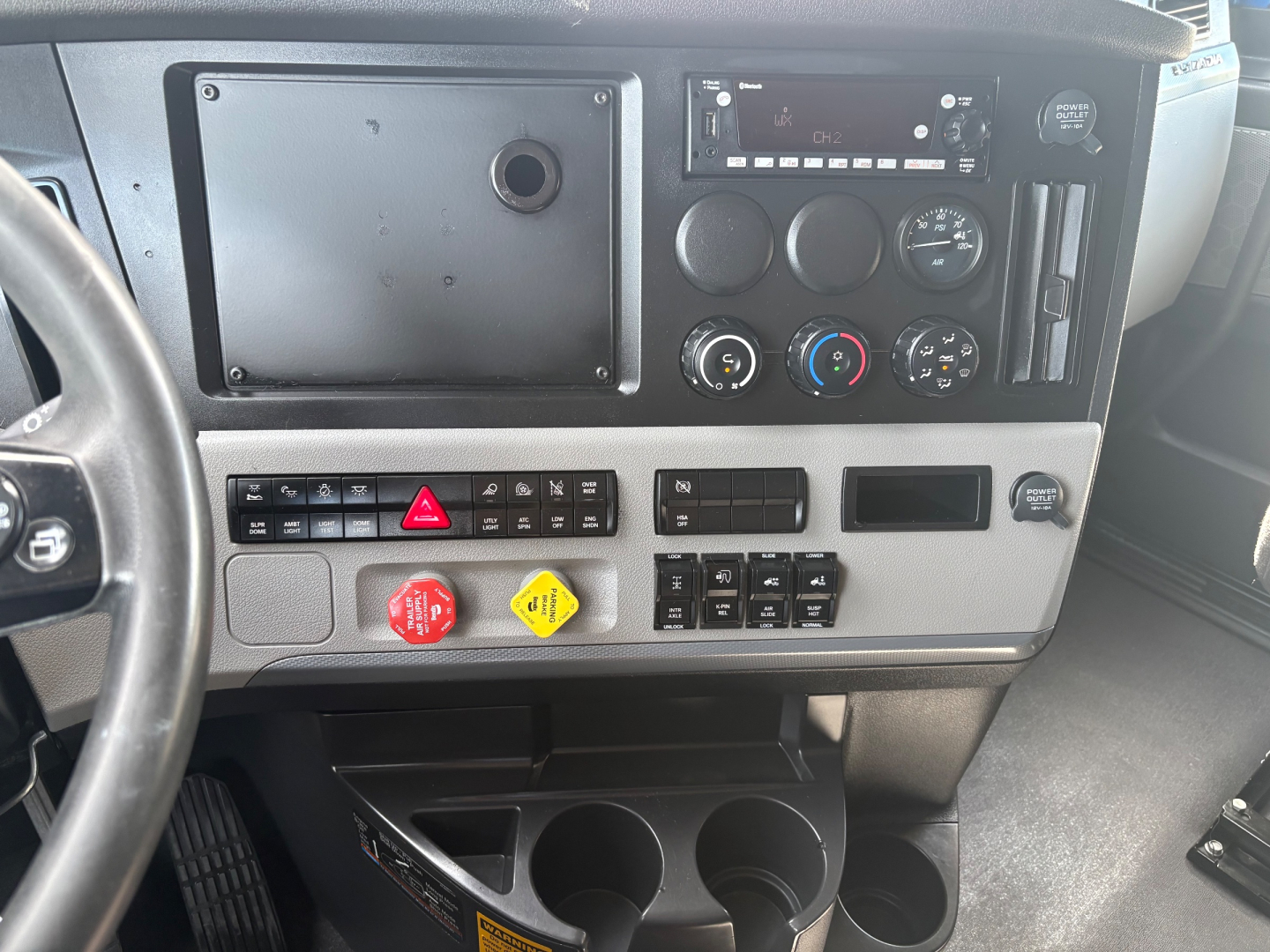 Cab interior of Freightliner PT126064ST showing dashboard controls, vents, and cupholders.