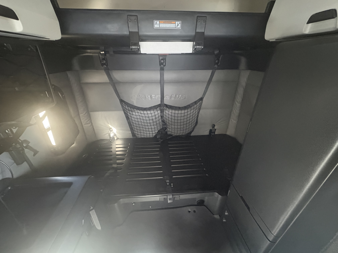 Freightliner PT126064ST truck interior cargo area with netted storage and belts visible.