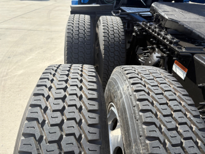 Trucks rear dual tires visible with tread pattern and wheel hubs; chassis and suspension components in view.