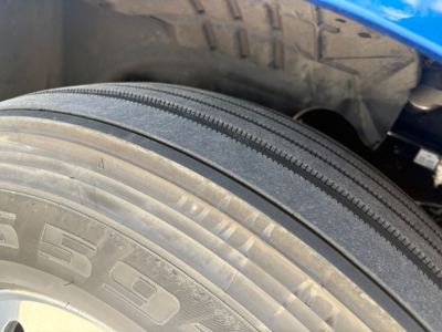Tire sole and fender area of a Freightliner PT126064ST showing a close-up of the front tire tread and wheel well.