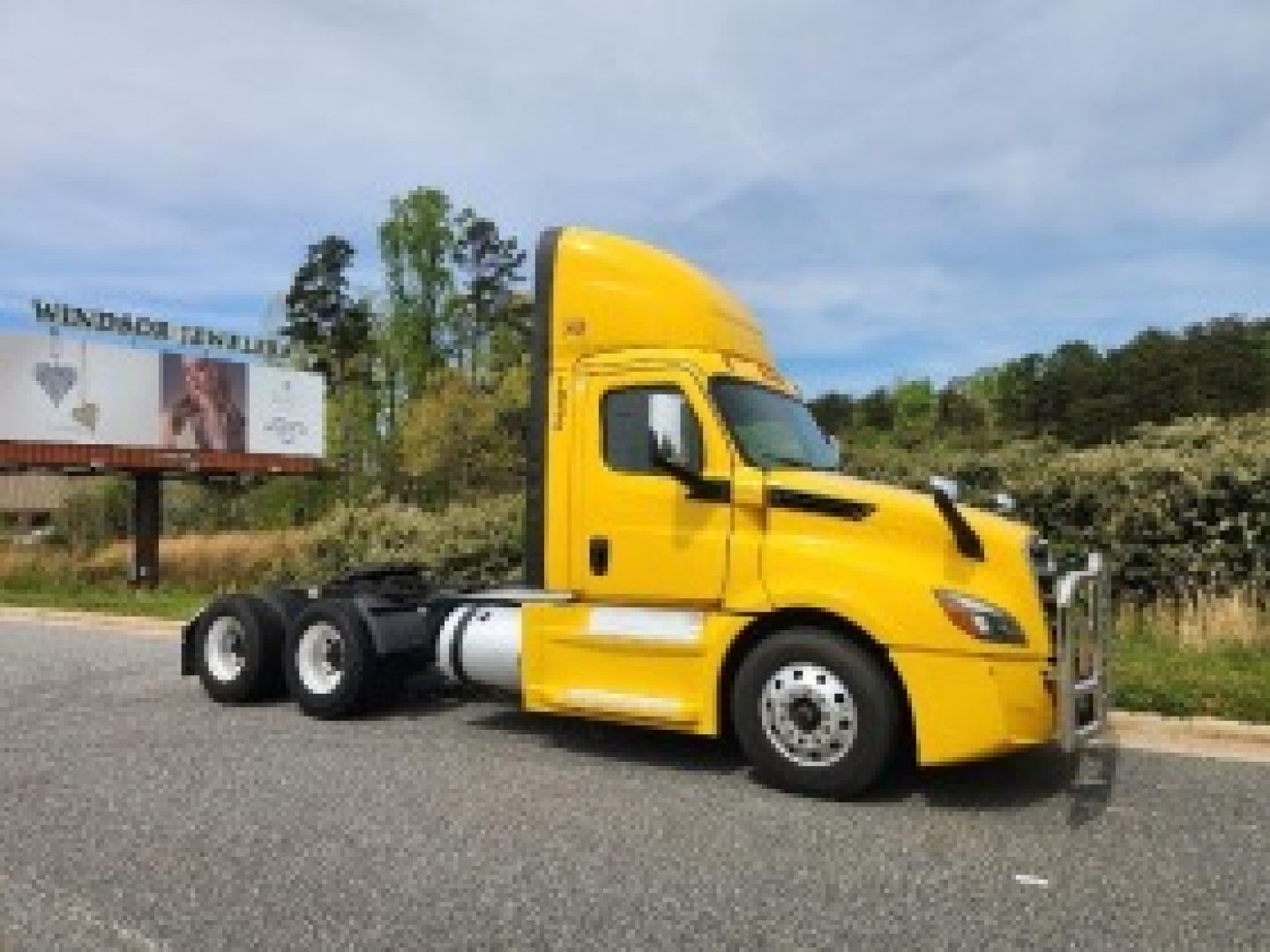 Yellow Freightliner Cascadia 126 daycab tractor in profile view with registration details visible in listing.