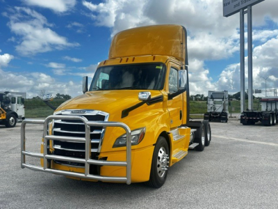 Freightliner Cascadia 126 daycab tractor in yellow showing front grille guard and cab. Visible text on badge and windshield not legible.