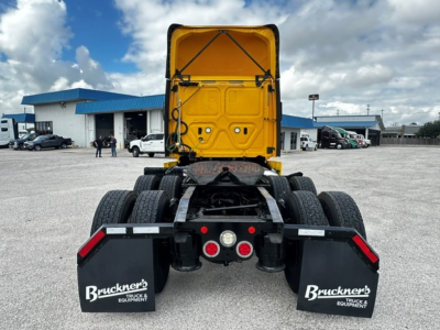 Truck rear view of a 2019 Freightliner Cascadia 126 day cab with fifth wheel, yellow cab, dual rear axles, mud flaps labeled Bruckner’s Equipment, in a dealership lot.