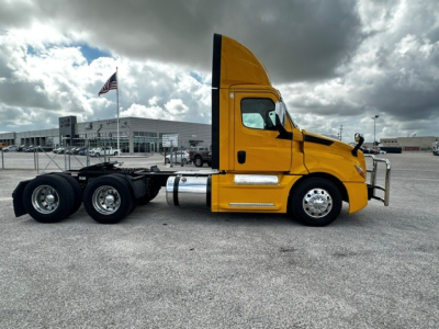 Truck side view showing a yellow 2019 Freightliner Cascadia 126 conventional daycab with triple rear axles and chrome fuel tanks.