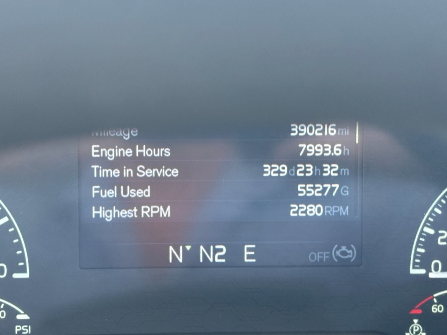 Volvo VNR dashboard display showing hours, time in service, miles, and RPM data; central digital readout with N N E compass below.