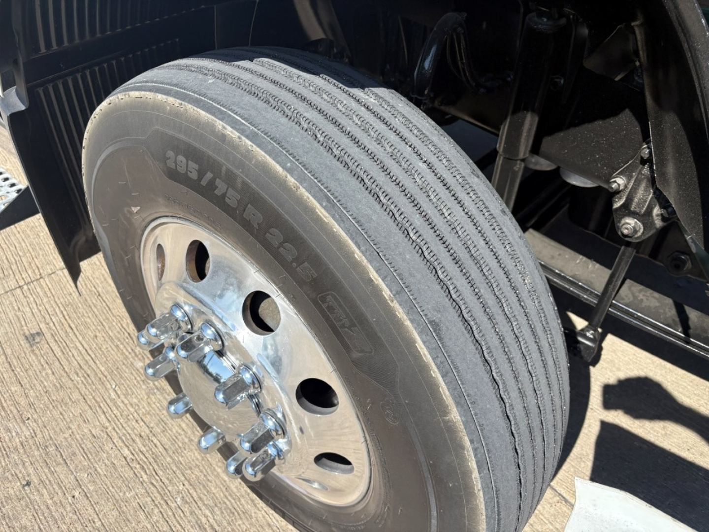 Volvo truck front left wheel showing 295/75R22.5 tire with dual hub and lug nuts visible.