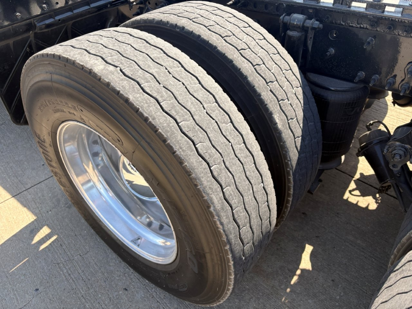 Volvo VNR truck dual rear wheels showing front tire tread and wheel well with metal components.