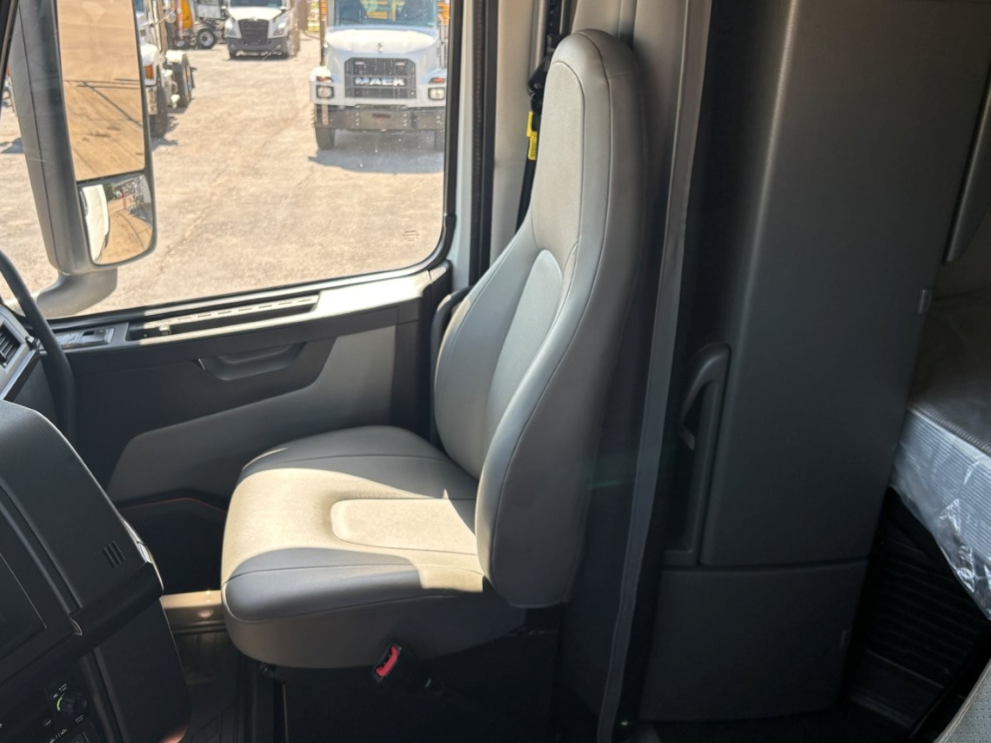 Cab interior of a Volvo VNR64T660 truck showing driver seat and surrounding console area.